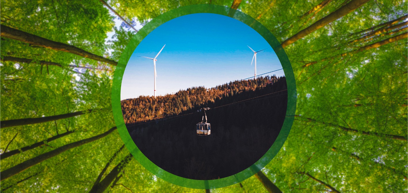 VAG Freiburg: Ökostrom und erneuerbare Energien für den ÖPNV Zwei Windkraftanlagen auf einem bewaldeten Hügel, davor eine Seilbahnkabine. Die Szene, umrahmt von grünen Baumkronen, visualisiert die Nutzung von Ökostrom aus regionaler Windkraft durch die Freiburger Verkehrs AG.
