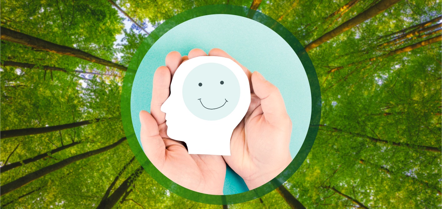 Psychische Gesundheit im ÖPNV: Soziale Verantwortung und Mitarbeiterschutz Zwei Hände halten einen weißen, stilisierten Kopf mit einem lächelnden Gesicht darauf. Die Szene, umrahmt von grünen Baumkronen, visualisiert die Bedeutung des Schutzes der psychischen Gesundheit und des Wohlbefindens.