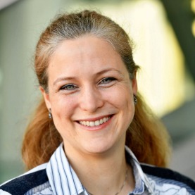 Nahaufnahme Porträt von Juliane Bartelt, Nachhaltigkeitsbeauftragte der MVG, die lächelt. Sie hat längere, zurückgebundene Haare und trägt eine weiß-blau gestreifte Bluse.