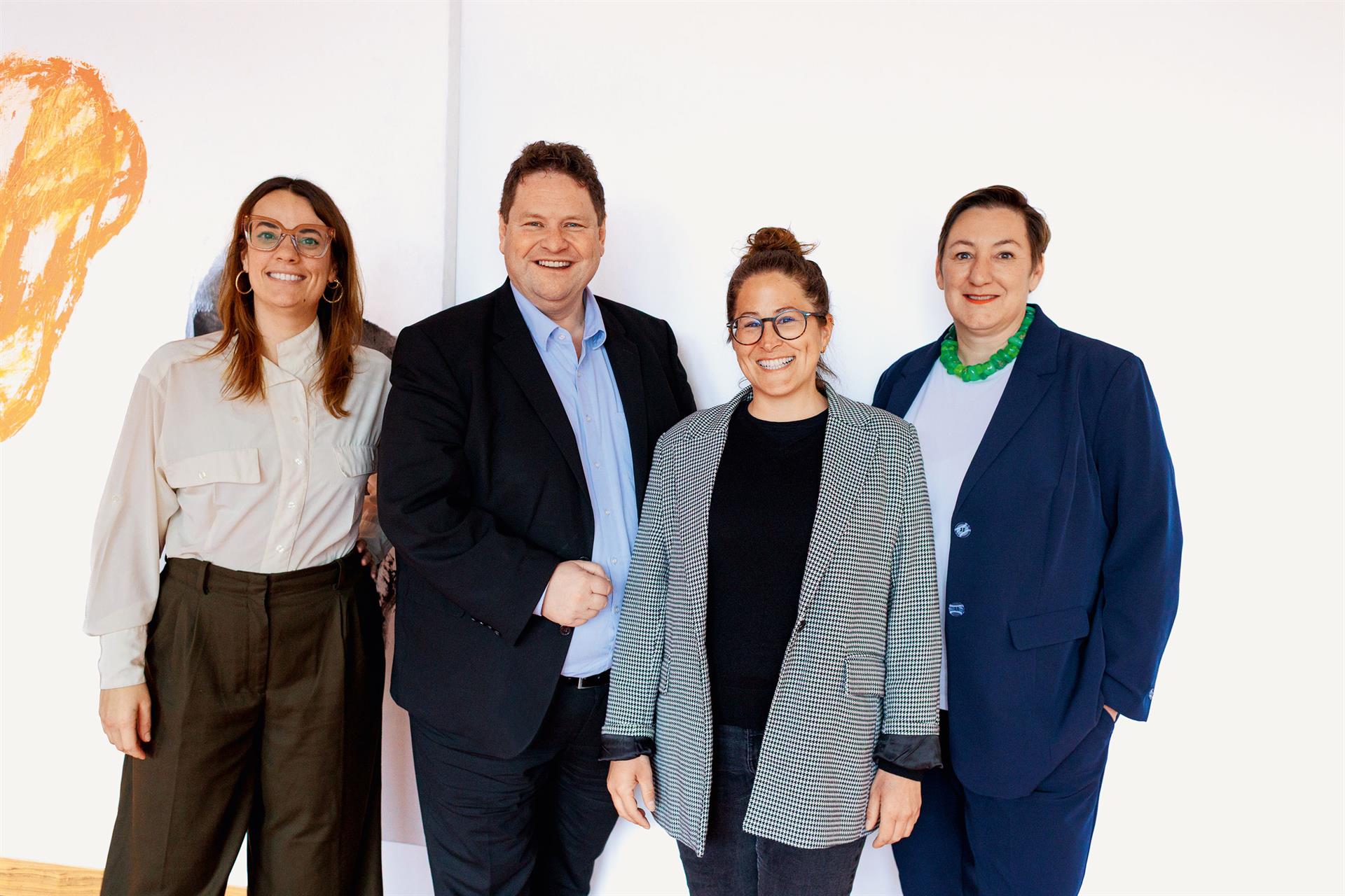Luftaufnahme einer Gleisbaustelle im herbstlichen Wald: Ein grüner Schienenkran hebt ein großes, gewölbtes Betonelement vor ein Tunnelportal der Hermann-Hesse-Bahn, um eine Einhausung für den Fledermausschutz zu errichten